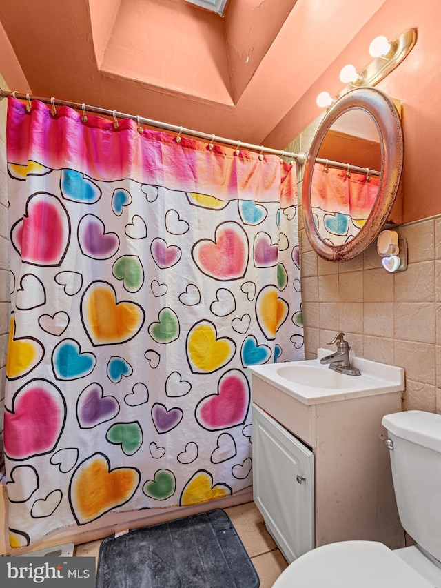 bathroom with toilet, decorative backsplash, tile walls, vanity, and curtained shower