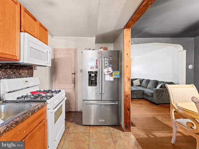 kitchen with decorative backsplash, white appliances, and light tile patterned floors