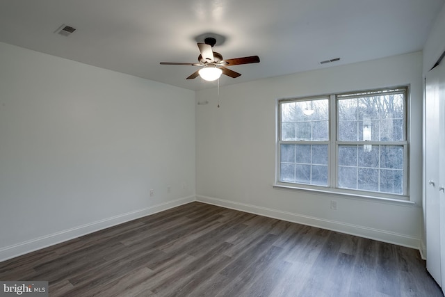 unfurnished room with ceiling fan and dark wood-type flooring