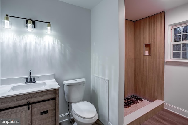 bathroom featuring toilet, walk in shower, wood-type flooring, and vanity