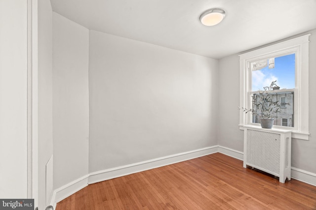 unfurnished room featuring light hardwood / wood-style floors and radiator