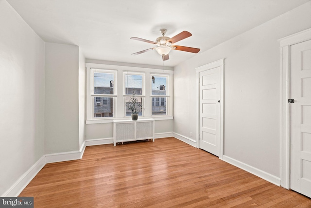 unfurnished bedroom featuring ceiling fan, light hardwood / wood-style flooring, and radiator heating unit