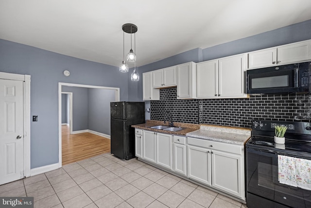 kitchen with decorative light fixtures, sink, white cabinetry, and black appliances