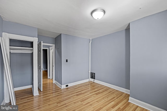 unfurnished bedroom featuring a closet and light hardwood / wood-style flooring