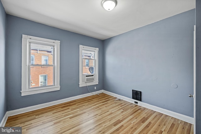 empty room with light wood-type flooring and cooling unit