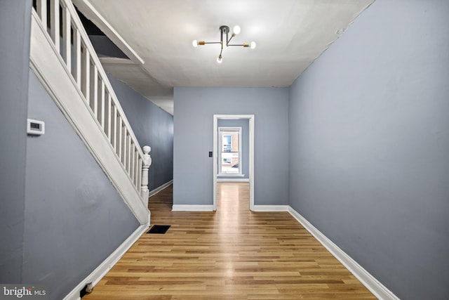 foyer featuring light wood-type flooring and a notable chandelier