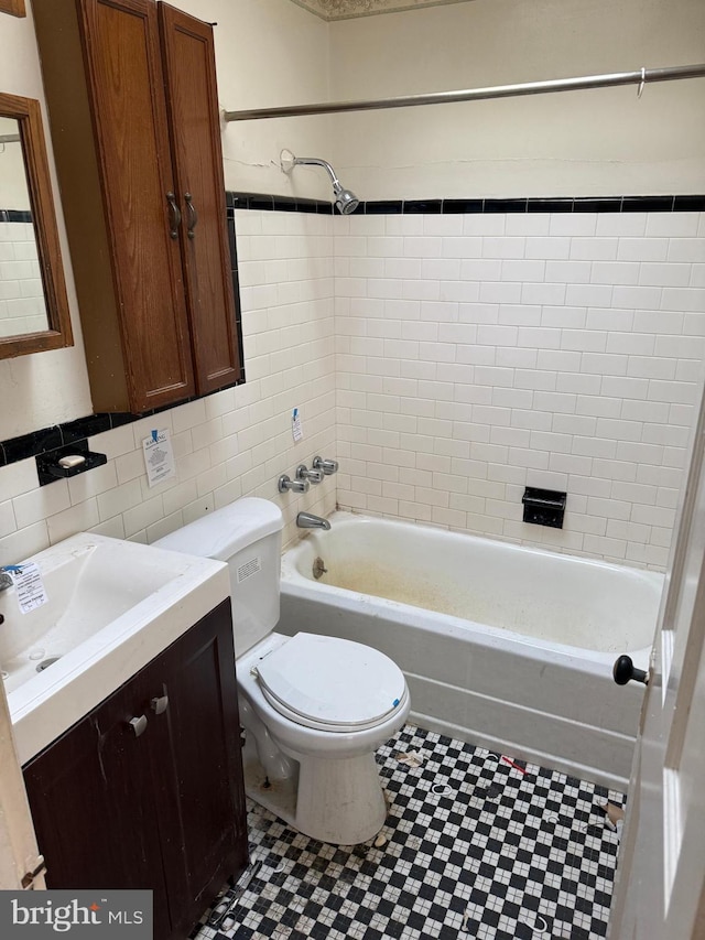 full bathroom featuring toilet, tile walls,  shower combination, and vanity