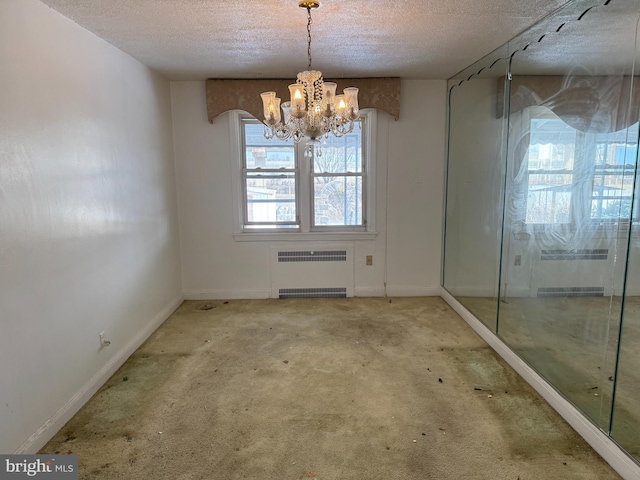 unfurnished dining area featuring a textured ceiling, radiator heating unit, light carpet, and a notable chandelier