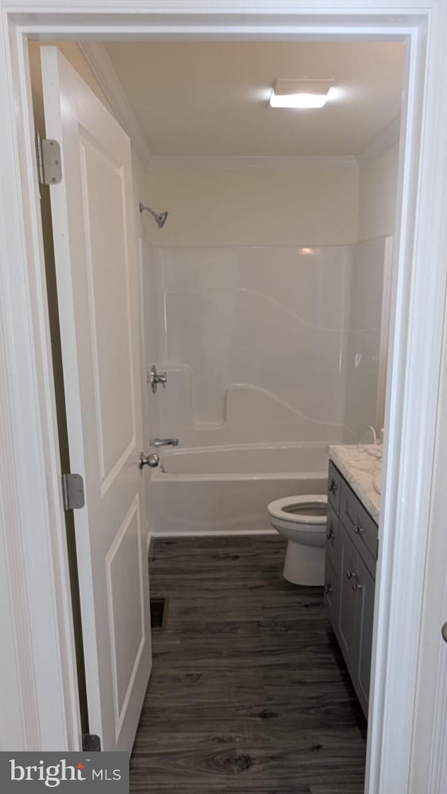 full bathroom featuring visible vents, toilet, wood finished floors, vanity, and shower / washtub combination