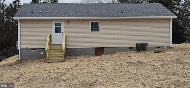 rear view of property with entry steps, roof with shingles, and crawl space