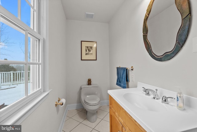 bathroom with toilet, vanity, and tile patterned flooring