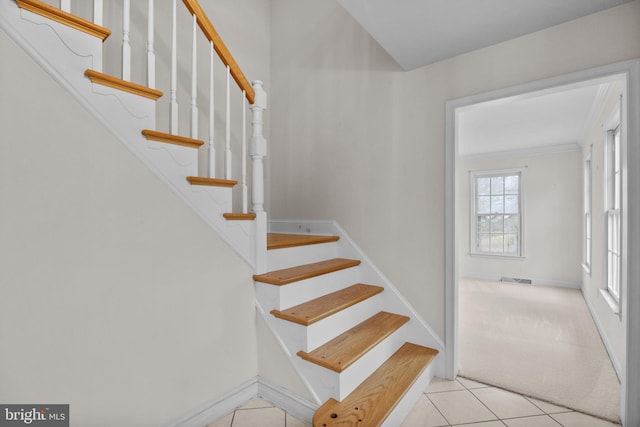 stairs featuring tile patterned flooring and ornamental molding