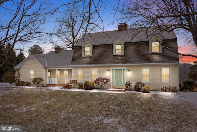 cape cod home with a yard