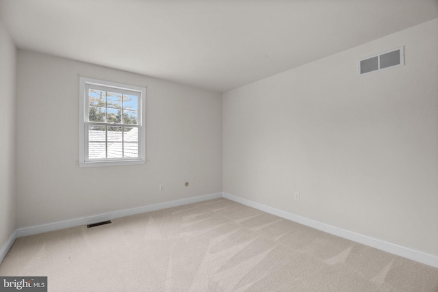 spare room featuring light colored carpet