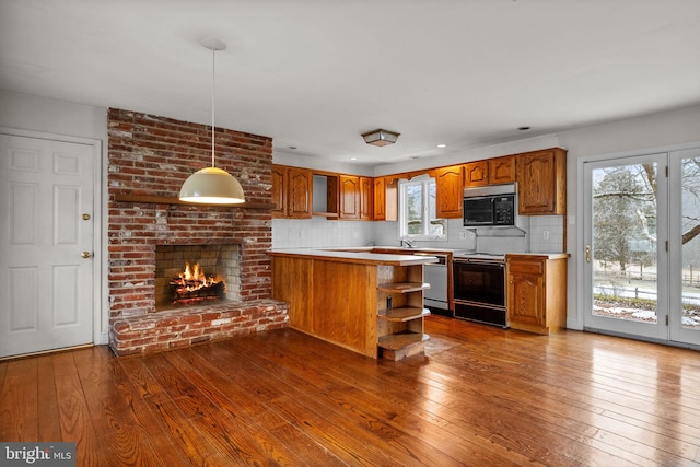 kitchen with decorative light fixtures, dark hardwood / wood-style floors, range with electric stovetop, and tasteful backsplash