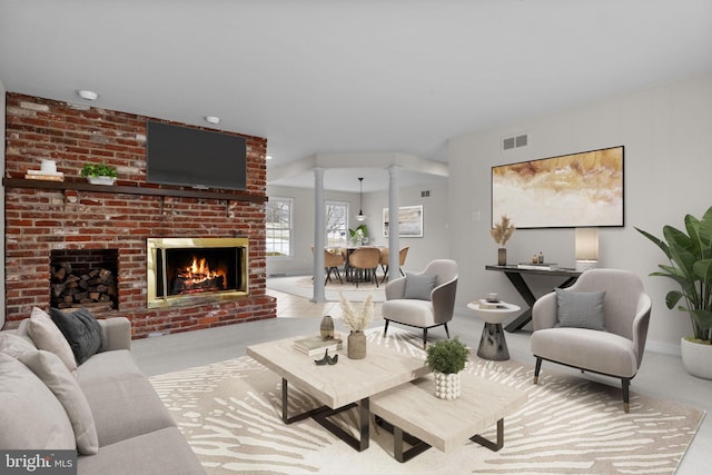 living room featuring light carpet, decorative columns, and a brick fireplace