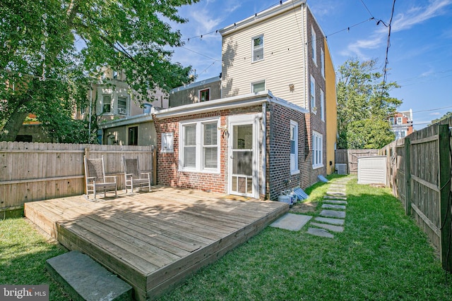 rear view of property with a lawn and a wooden deck