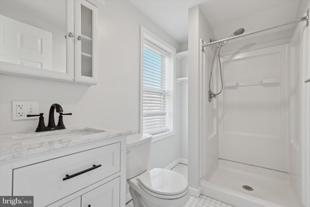 bathroom with toilet, a shower, a healthy amount of sunlight, and vanity