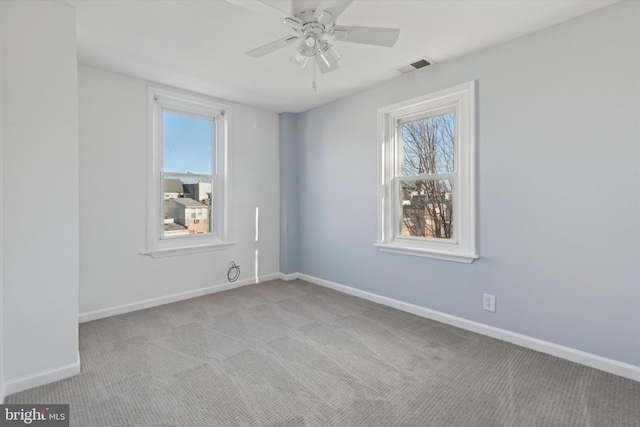 carpeted empty room featuring ceiling fan and a wealth of natural light