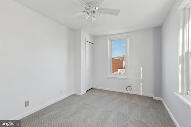 carpeted spare room with ceiling fan