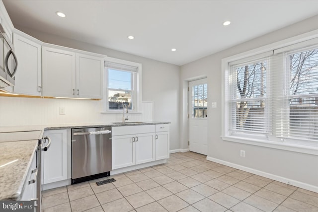 kitchen with stainless steel appliances, light tile patterned flooring, white cabinets, and sink