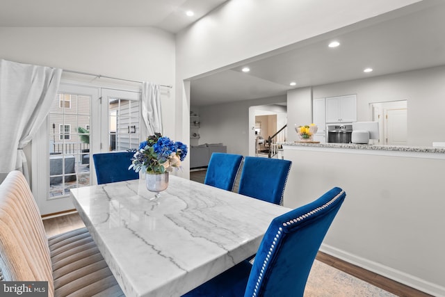 dining space featuring hardwood / wood-style flooring and vaulted ceiling