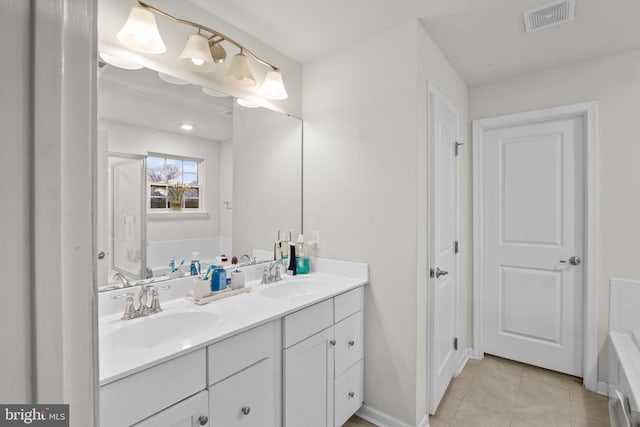 bathroom featuring tiled tub, tile patterned floors, and vanity