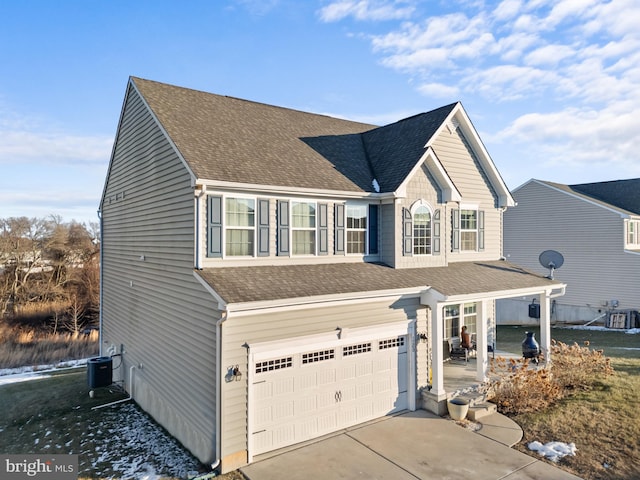 view of front property featuring a garage and central AC