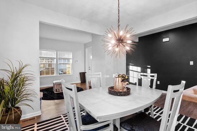 dining space with a notable chandelier and hardwood / wood-style flooring