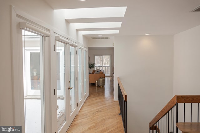 hall featuring light wood-style floors, visible vents, and recessed lighting