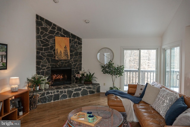 living area featuring lofted ceiling, a fireplace, and wood finished floors