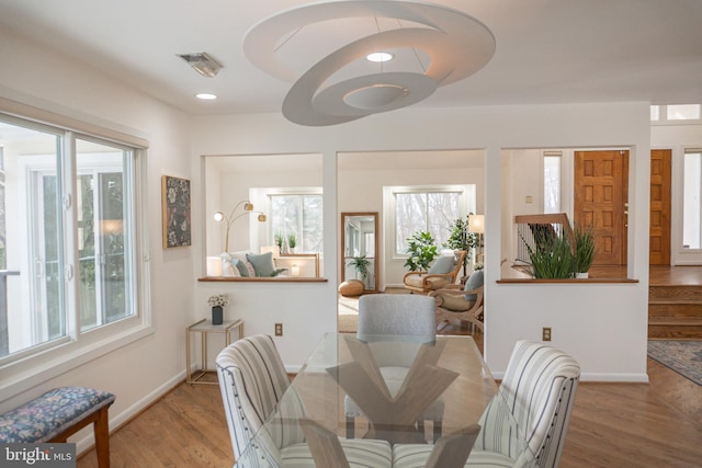 dining room featuring baseboards, visible vents, wood finished floors, and recessed lighting