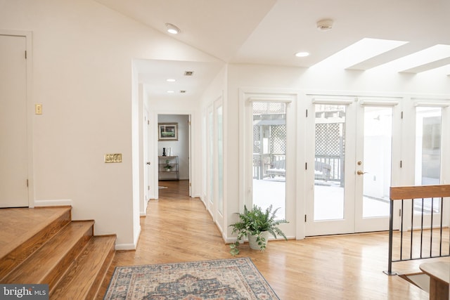 doorway to outside with a healthy amount of sunlight, stairway, and lofted ceiling