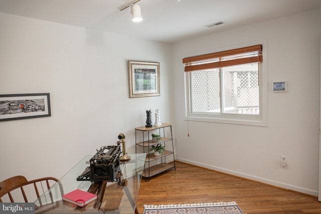 sitting room featuring track lighting, visible vents, baseboards, and wood finished floors