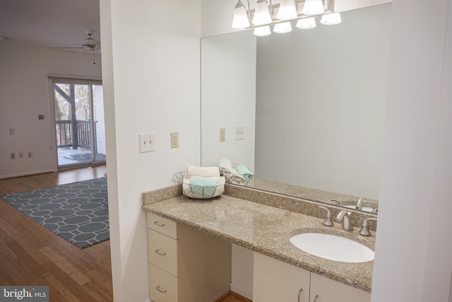 bathroom with a ceiling fan, wood finished floors, and vanity