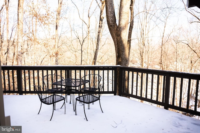 snow covered deck featuring outdoor dining space