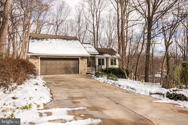 view of front of property with a garage, stone siding, and concrete driveway