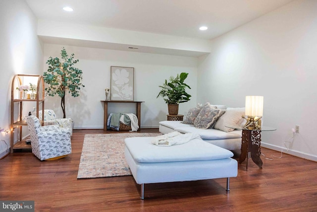 living room featuring baseboards, wood finished floors, and recessed lighting