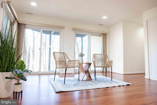 sitting room with baseboards, wood finished floors, and recessed lighting