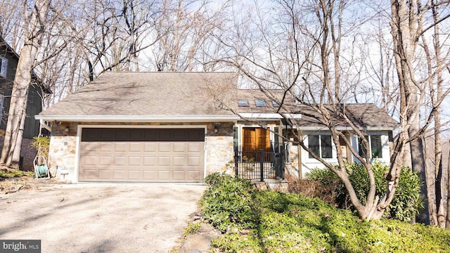 single story home featuring driveway, stone siding, an attached garage, and a shingled roof