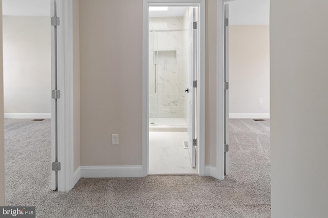 hallway featuring light colored carpet