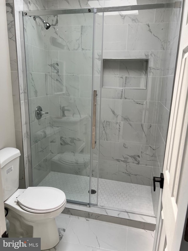 bathroom featuring toilet and walk in shower