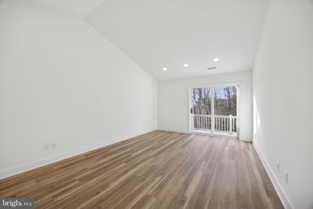 unfurnished room with vaulted ceiling and wood-type flooring