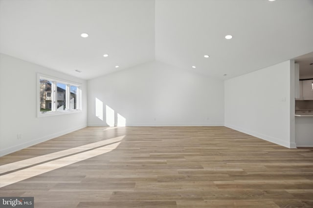 unfurnished living room with light wood-type flooring and vaulted ceiling