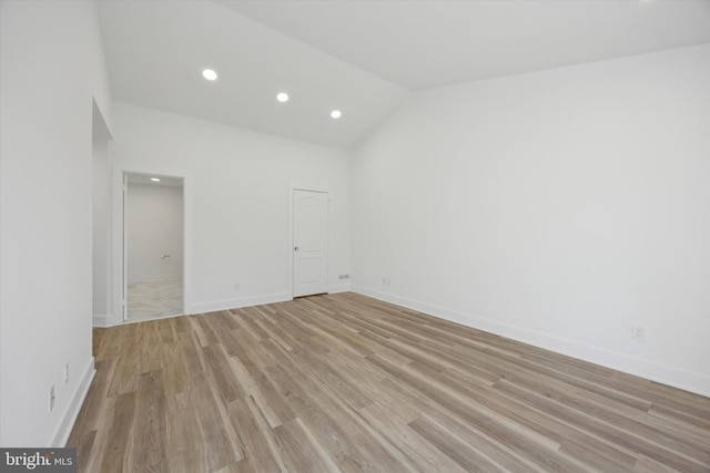 unfurnished room with high vaulted ceiling and light wood-type flooring