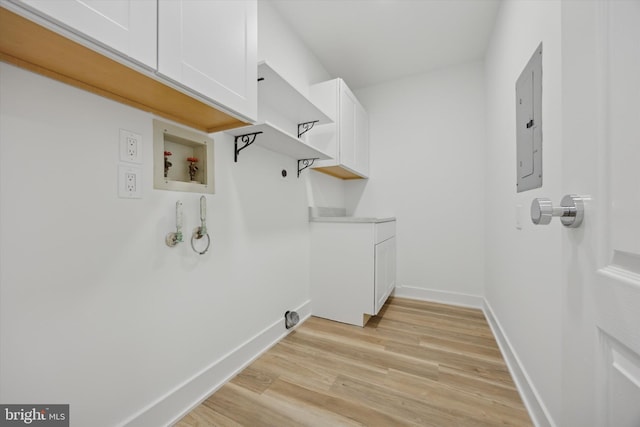 clothes washing area featuring electric panel, electric dryer hookup, cabinets, gas dryer hookup, and washer hookup