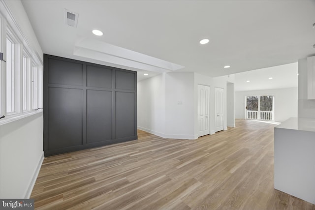 unfurnished living room featuring a wealth of natural light and light hardwood / wood-style flooring