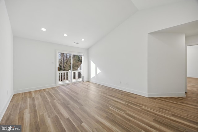 unfurnished room featuring light wood-type flooring and lofted ceiling