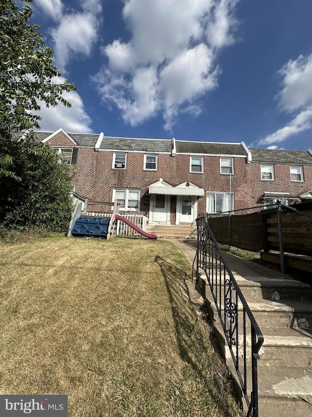 rear view of property with a yard