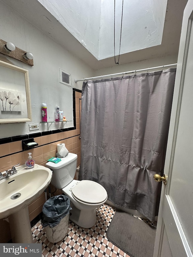 full bathroom with tile walls, toilet, tile patterned floors, decorative backsplash, and shower / bath combination with curtain